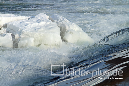 Wehr am Fluss mit Eis und Schnee